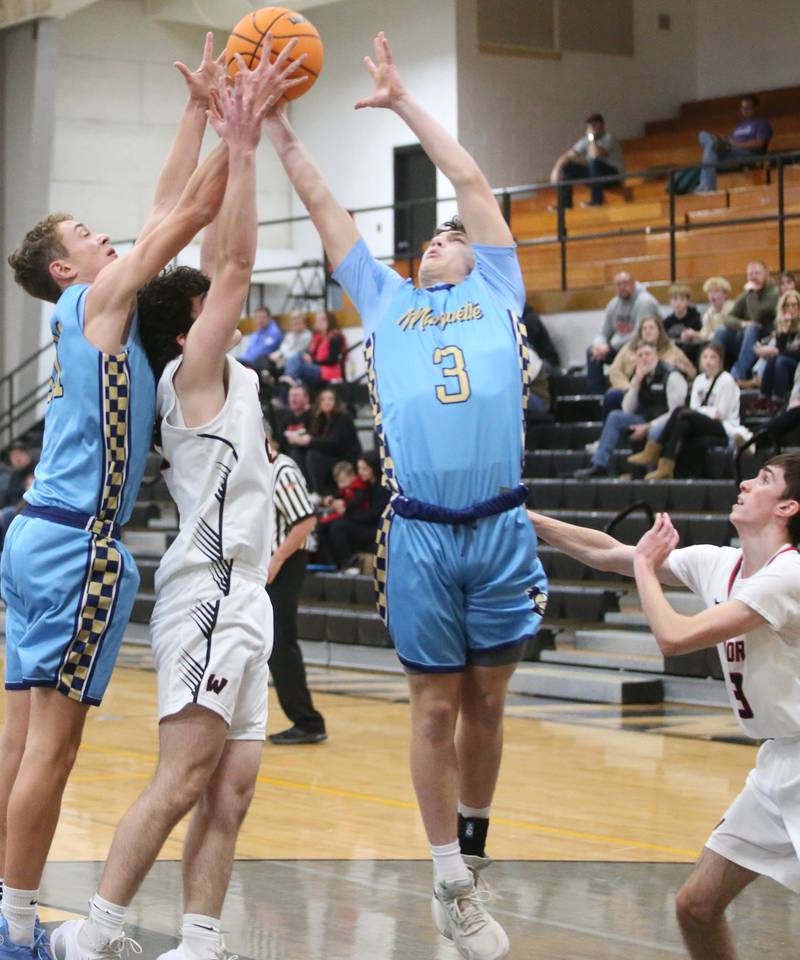 Marquette's Lucas Craig and teammate Easton Debernardi grab a rebound over Woodland's Brezdyn Simons during the Tri-County Conference Tournament on Tuesday, Jan. 28. 2025 at Putnam County High School.