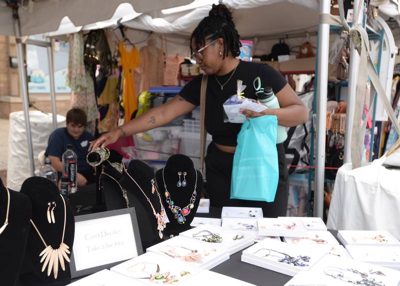 Reagan Bond of Willowbrook buys some of the jewelry sold by Lisa Davis of Oak Lawn during the Taste of Westmont Saturday July 12, 2025.