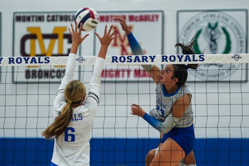 St. Charles North's Haley Burgdorf (23) goes up for a kill attempt against Rosary’s Emily Eissens (6) during a volleyball game at Rosary High School in Aurora on Monday, Aug 25, 2025.