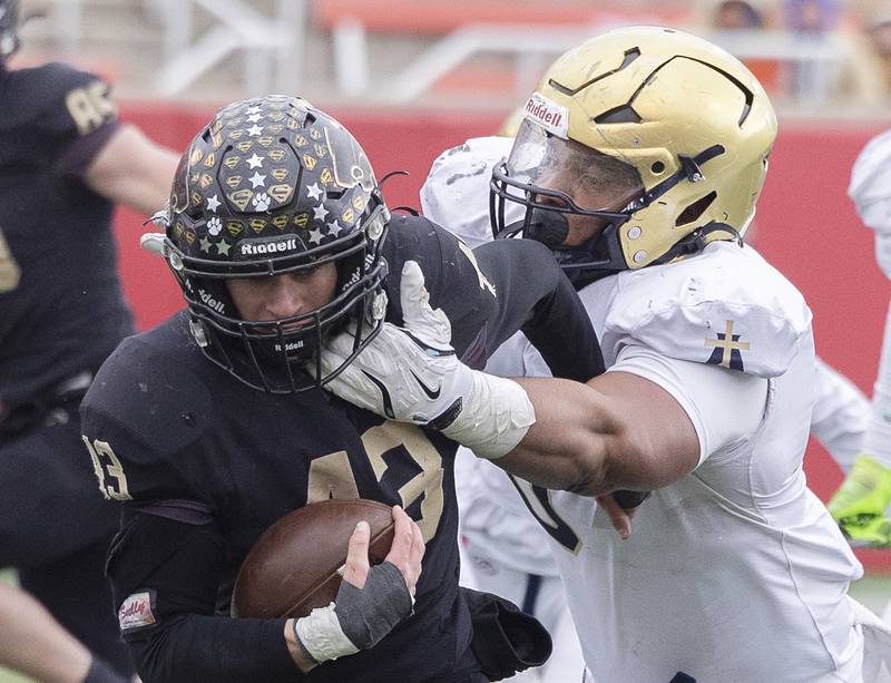 Lena-Winslow's Alec Schlichting is pulled down by Althoff Catholic’s Jason Dowell Friday, Nov. 29, 2024, in the class 1A football state final.