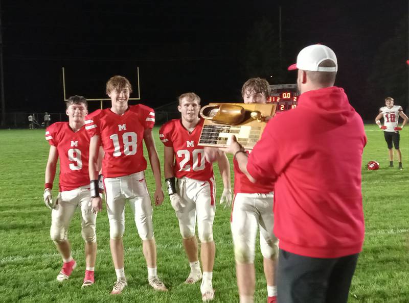 Morrison Mustangs players receive the Wooden Shoe traveling trophy after defeating rival Fulton 31-21 Friday, Oct. 17, 2025 in Morrison.
