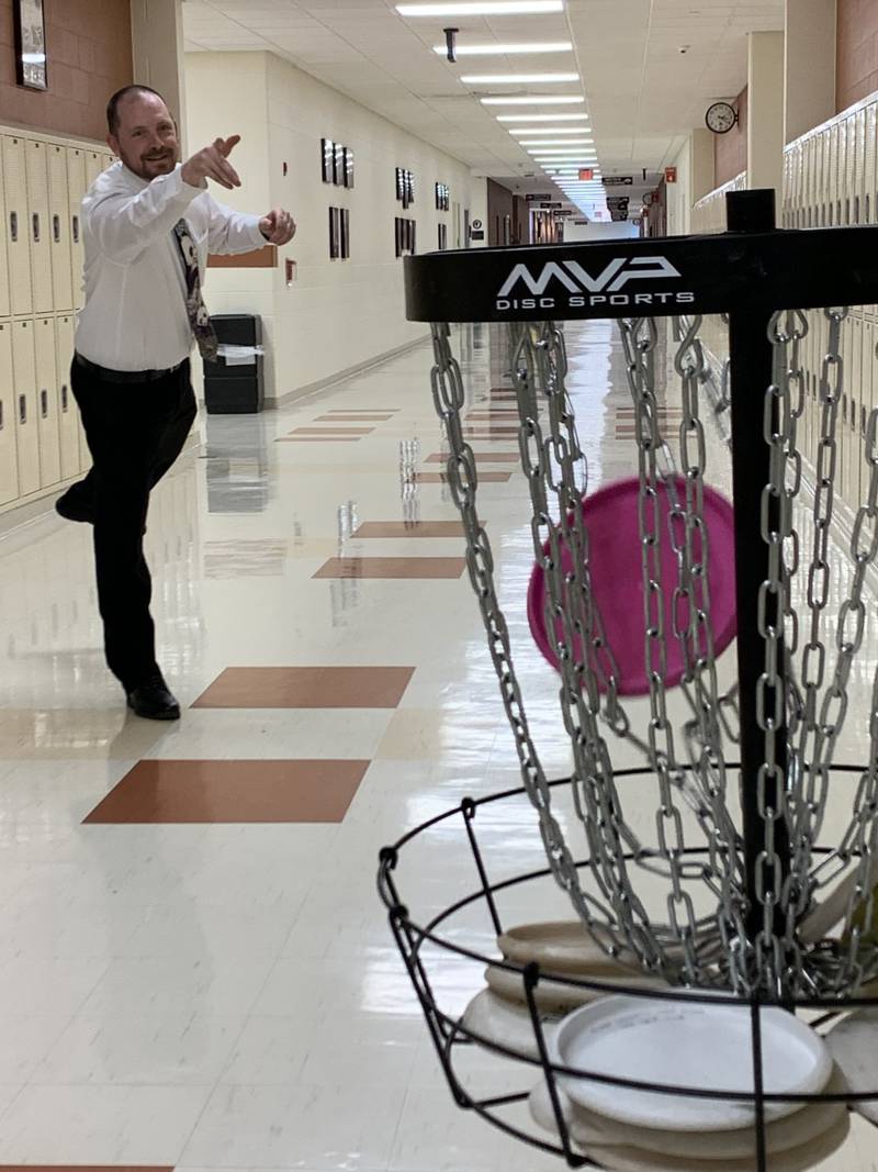 Math teacher, Jason Allen plays disc golf in the hallways of Minooka Community High School.