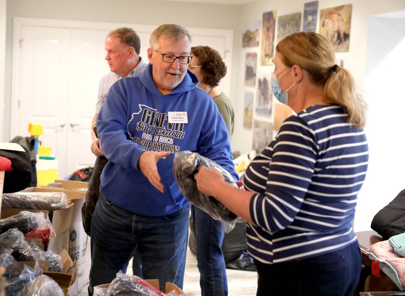 Chuck Miles of the Rotary Club of Batavia helps Tassie Brautigam gather children’s winter coats to be donated to the Salvation Army, Lazarus House and area schools.