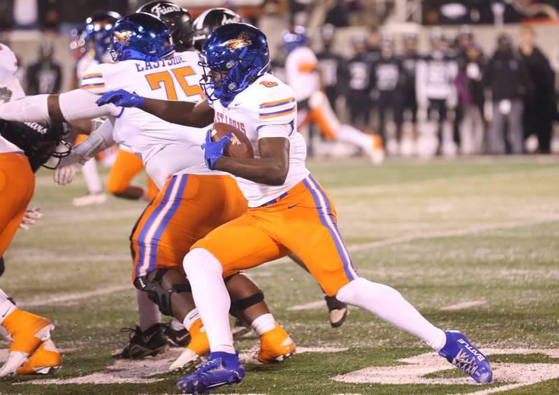 East St. Louis's Myson Johnson-Cook runs the ball East St. Louis quarterback Reece Shanklin throws a pass during the Class 6A State championship game on Tuesday, Dec. 2, 2025 in Hancock Stadium at Illinois State University in Normal.