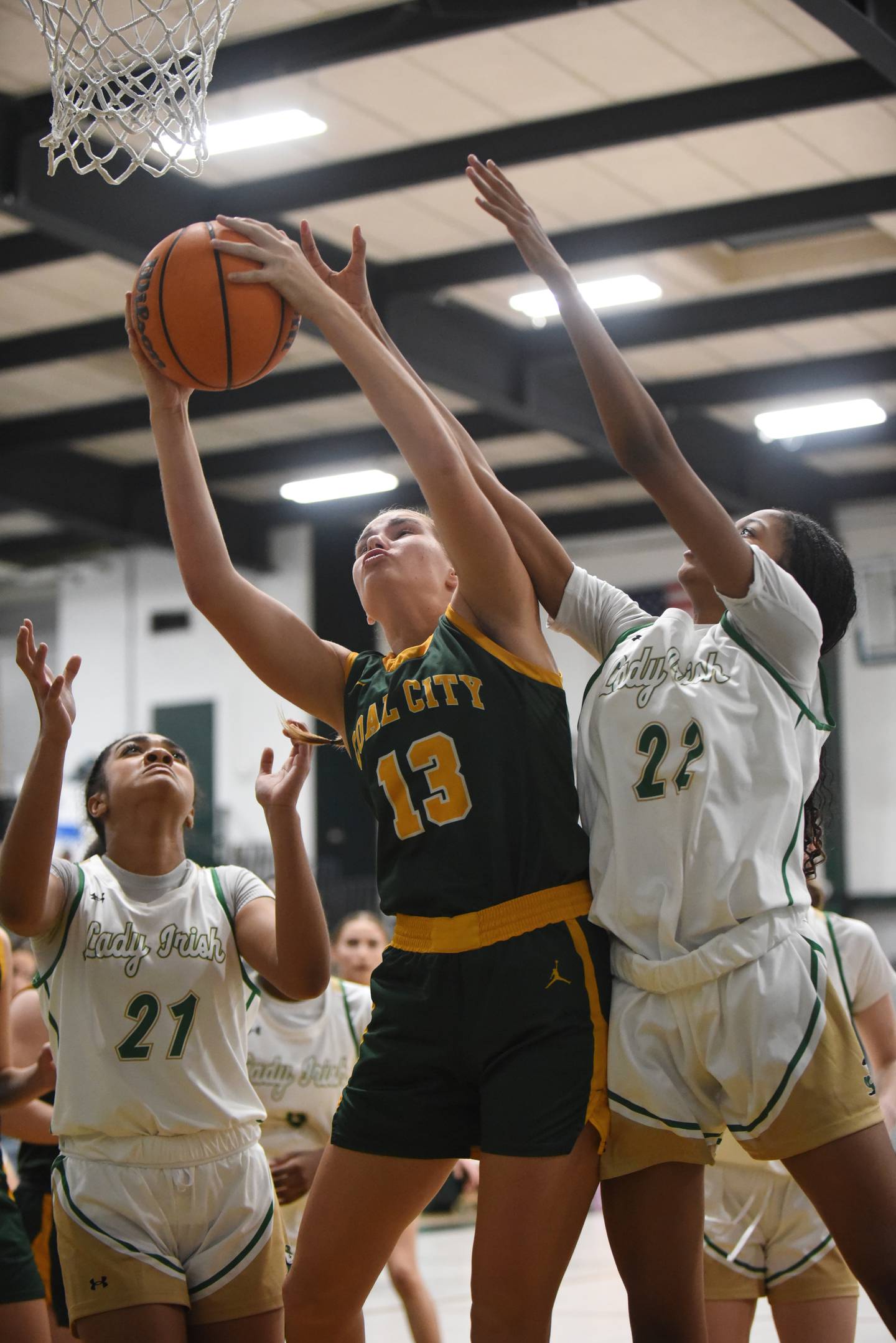 Coal City's Kyla Stark, center, grabs a rebound between Bishop McNamara's Keneyce Davis, left, and Leah Hutson during a game at Bishop McNamara Tuesday, Nov. 25, 2025.