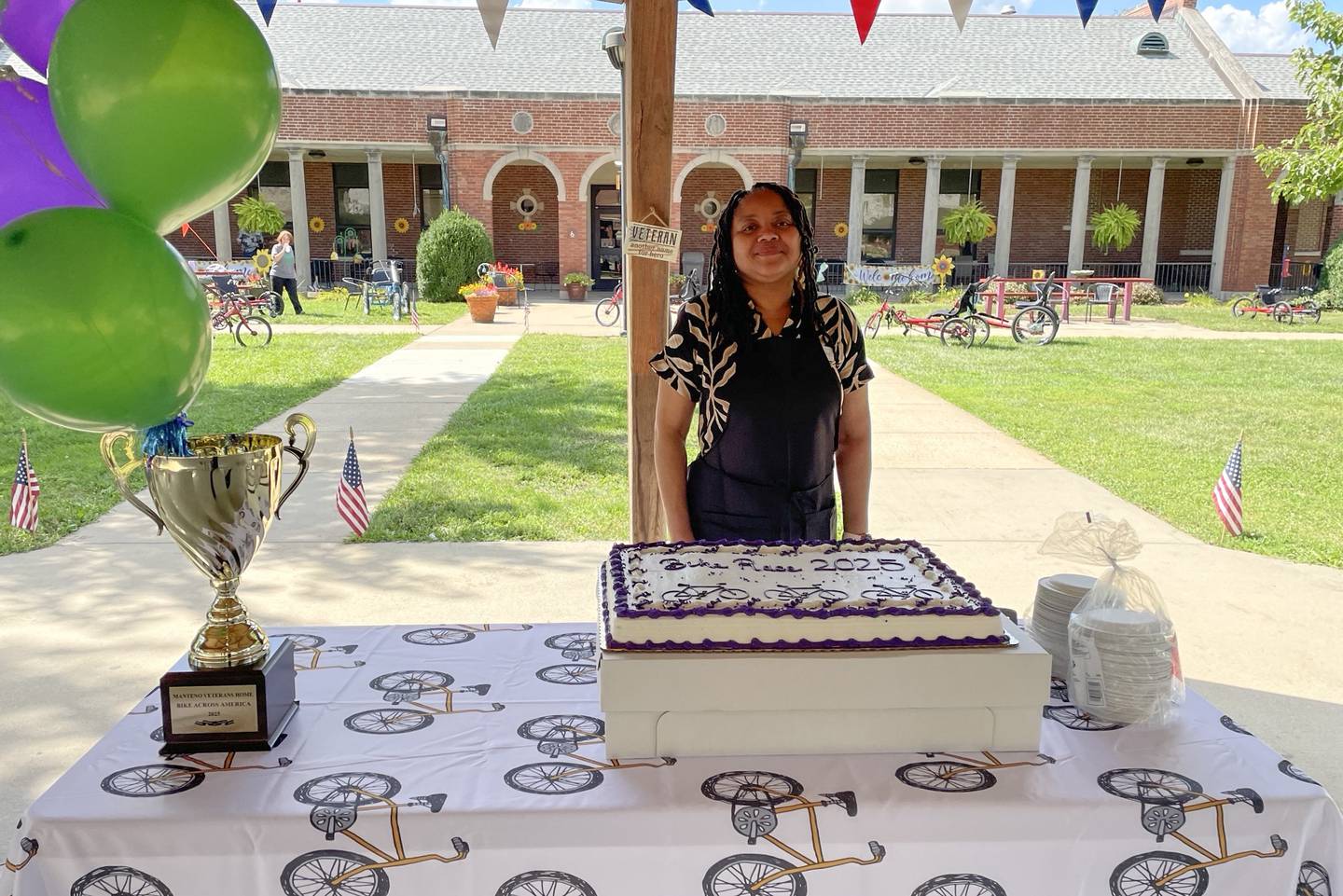 A Manteno Veterans' Home staff member stands with the cake and trophy during the awards ceremony for the home's Bike Across America challenge on Sept. 2, 2025.