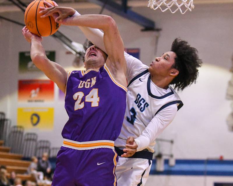 Downers Grove North's Aidan Akkawi (24) makes a basket while being fouled by Downers Grove South's Adam Flowers (3) during the game on Saturday Dec. 21, 2024, held at Downers Grove South High School.