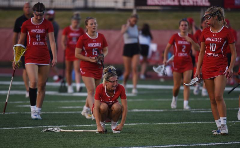Hinsdale Central players including Ari Tavoso, middle, and Parker Matthews, right, react to their team’s loss to Loyola Academy during the girls state lacrosse championship in Hinsdale Saturday, June 3, 2023.