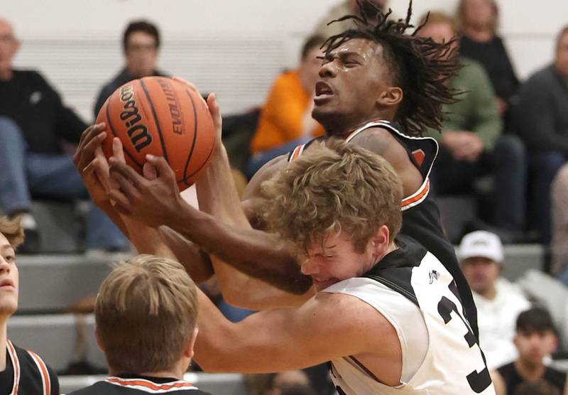 DeKalb's Darrell Island and Kaneland's Parker Violett go after a rebound during their game Tuesday, Jan. 24, 2023, at Kaneland High School.