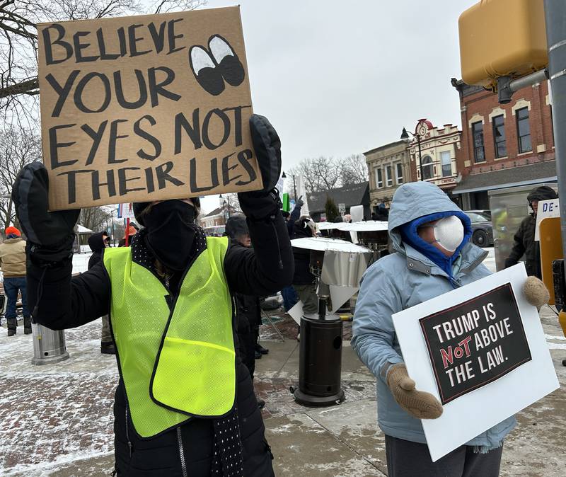 Two people hold signs during Indivisible of Ogle County's protest in downtown Oregon on Sunday, Jan. 25, 2026. Approximately 120 people attended the protest criticizing the Trump administration's deployment of ICE officers and the shooting death of Alex Pretti by ICE agents on Saturday in Minneapolis.