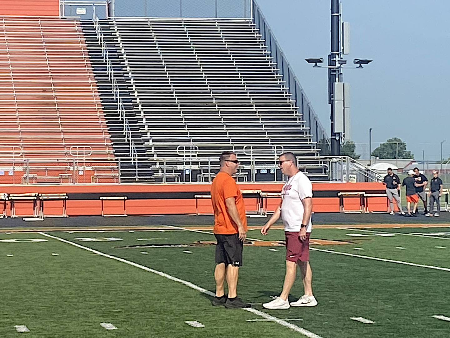 Minooka coach Matt Harding (left) and Morris coach Alan Thorson talk during Thursday's joint football practice.