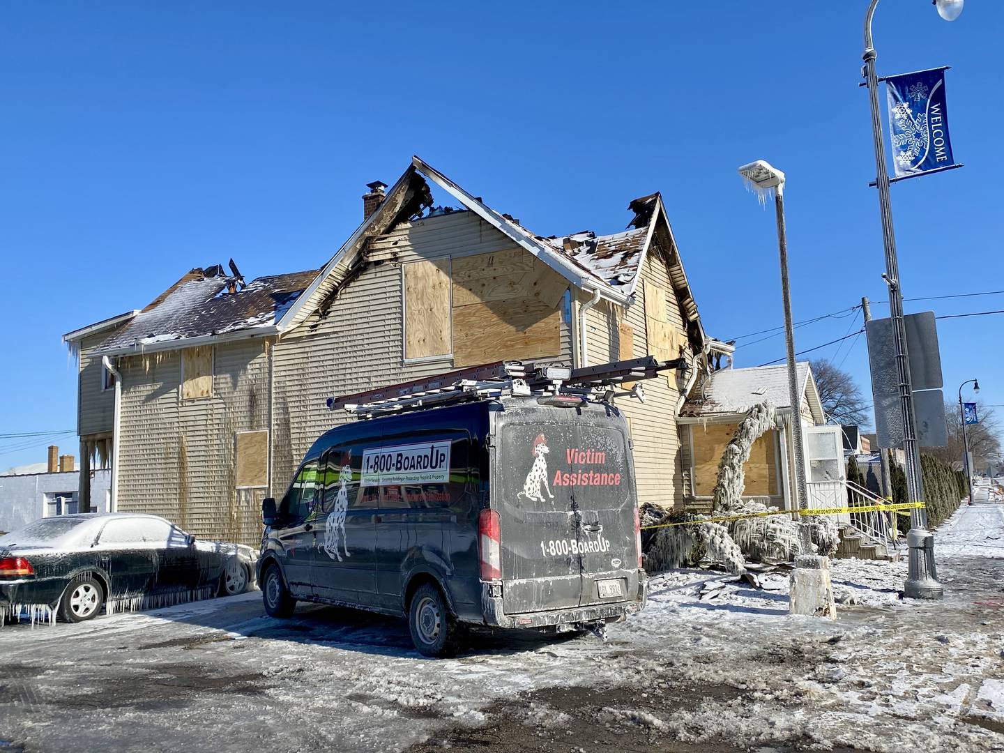 A service truck is parked outside a two-story duplex ravaged by fire in the 700 block of East Lincoln Highway in downtown DeKalb on Monday, Jan. 26, 2026. Authorities with the DeKalb Fire Department and city building inspectors have roped off the area to passersby and traffic. An accidental fire caused by an attempt to thaw frozen pipes in the basement destroyed the building on Saturday, Jan. 24, 2026.