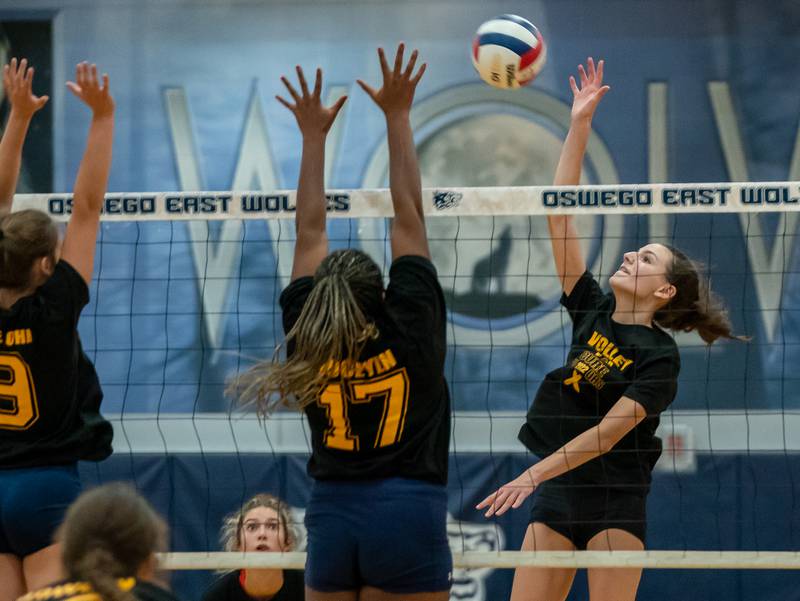 Oswego’s Mia Jurkovic (right) goes up for a kill against Oswego East's Vivian Campbell (17) and Kylie Kany (9) during a volleyball match at Oswego East High School on Thursday, Sep 15, 2022.
