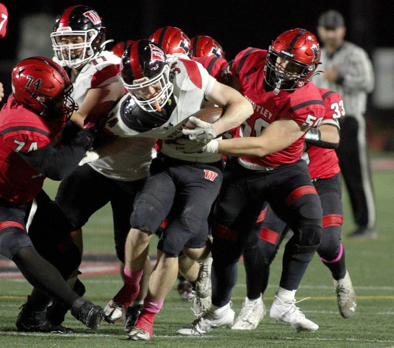 Niles West’s Joseph Pantazis, center, runs the ball as  Huntley’s  Ben Cohen, right, prepares to tackle in first-round Class 8A playoff football action at Huntley Friday.