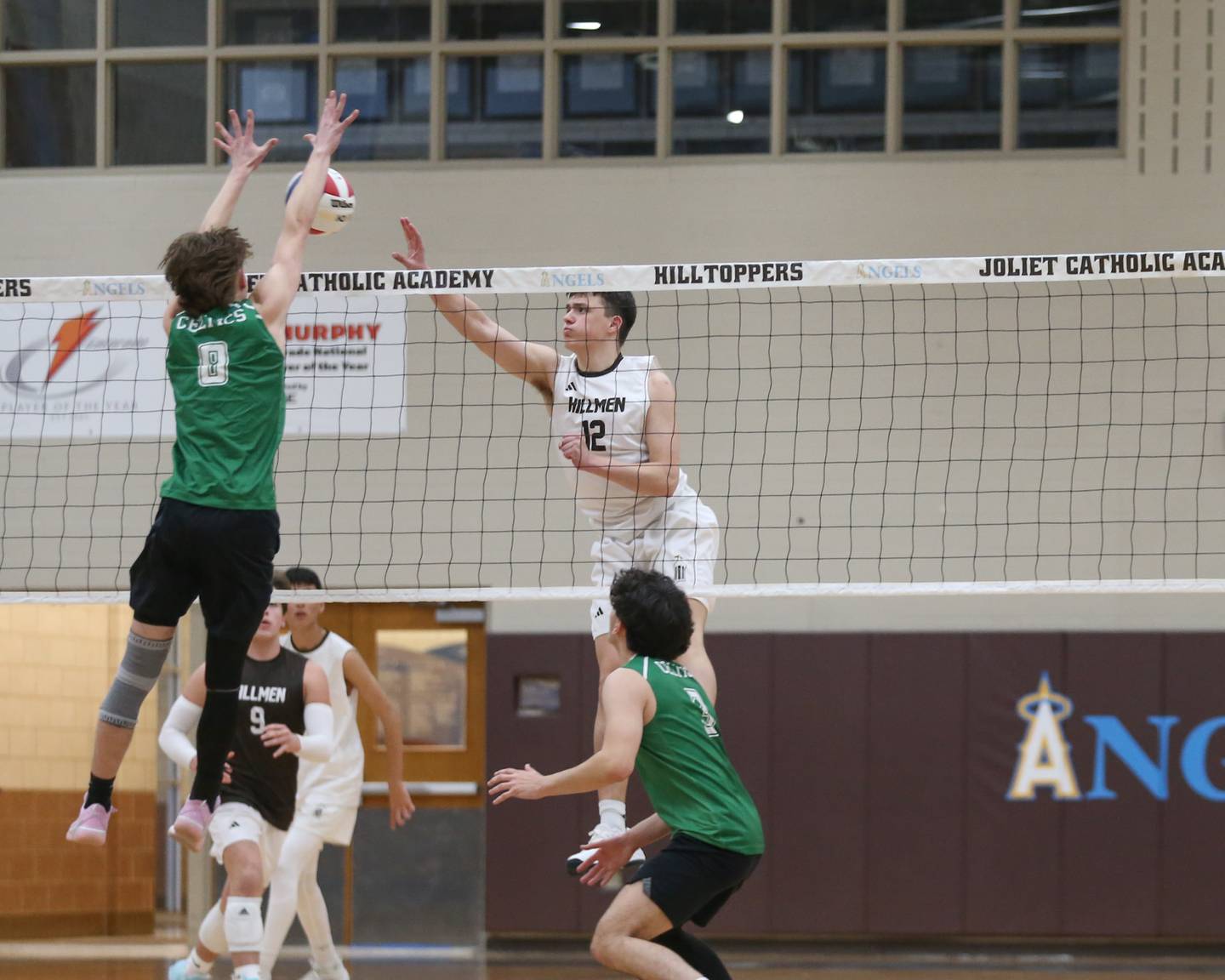 Joliet Catholic's Austin Bernhard (12) spikes the ball over the net during volleyball match between Providence Catholic at Joliet Catholic.  March 25, 2025.