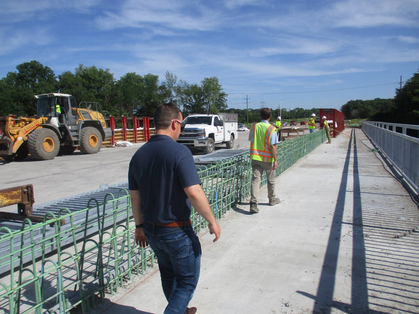 The bicycle path along the east side of the Elamain Road bridge is flanked by a galvanized steel railing to the right and what will be a concrete parapet wall to the left, separating the bike trail from motor vehicle traffic. At the bottom of the steel framing for the wall is conduit for fiber optic cable. (Mark Foster -- mfoster@shawmedia.com)