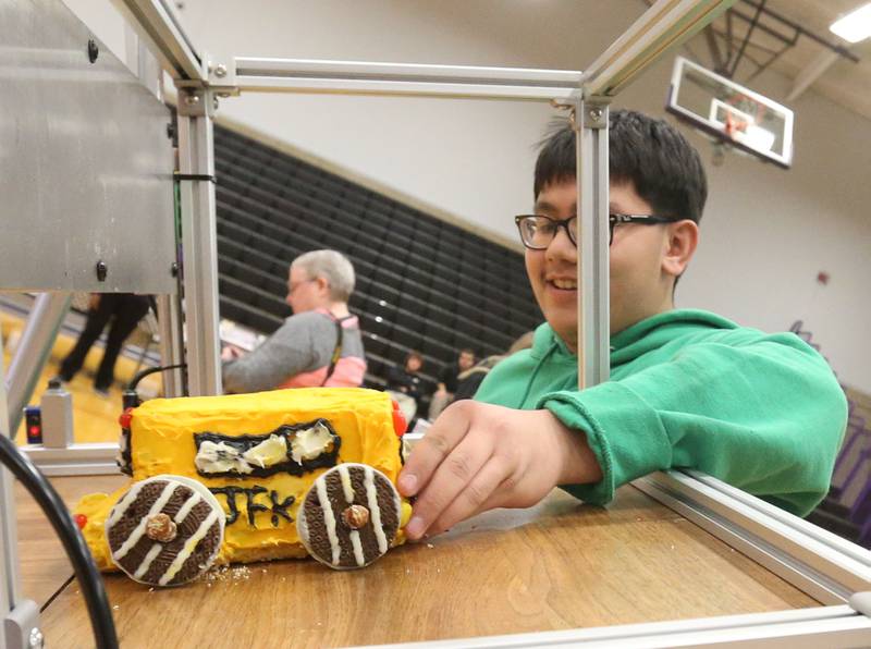 Mehki Saephan, an eighth grader at JFK School in Spring Valley, pushes his JFK yellow bus car down the ramp during the Edible Car Contest on Wednesday, Feb. 25, 2026 at Illinois Valley Community College in Oglesby.
