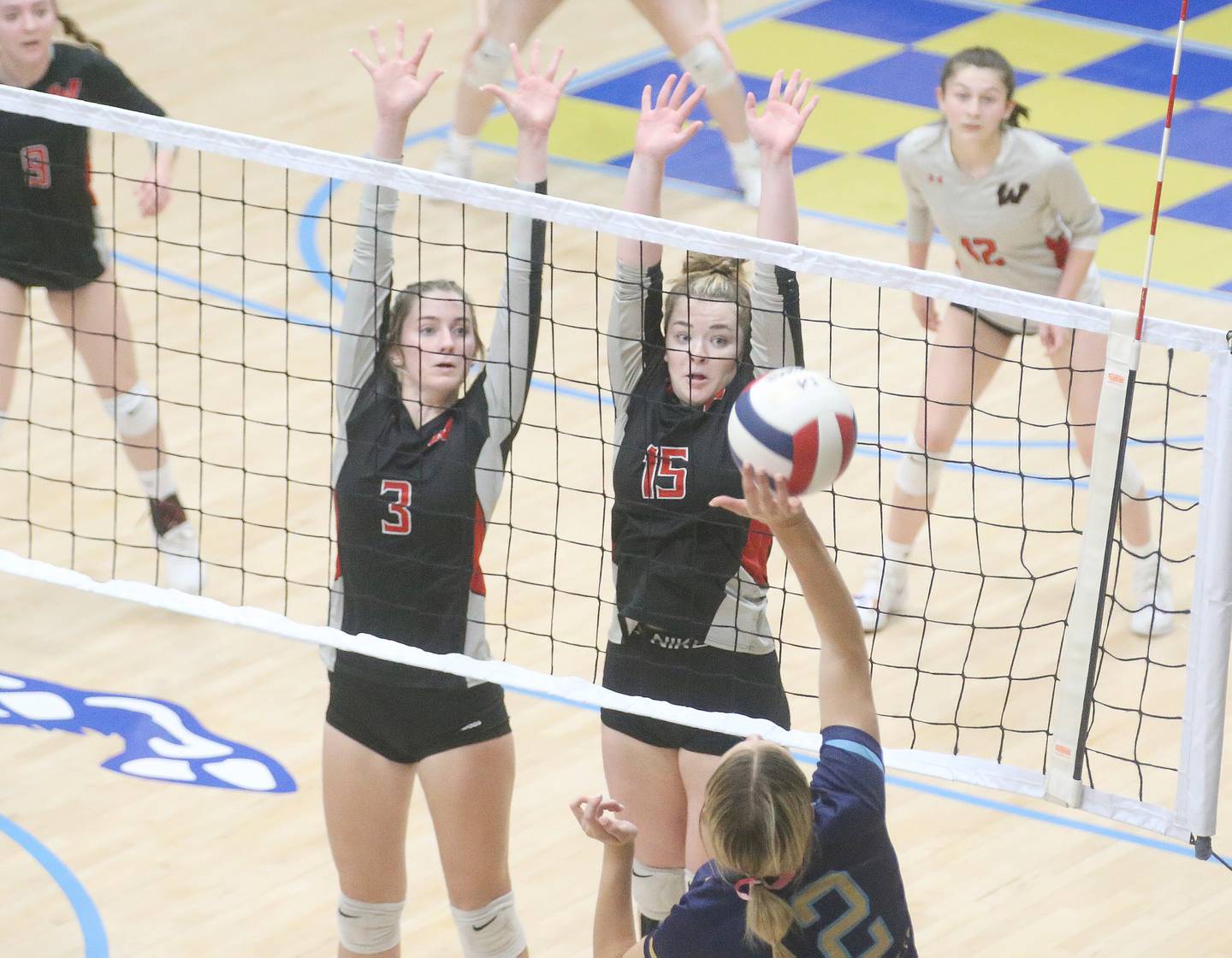 Woodland's Malayna Pitte and Elizabeth Schultz jump to try to block a spike from Marquette's Lilly Craig on Thursday, Oct. 19, 2023 at Bader Gym.