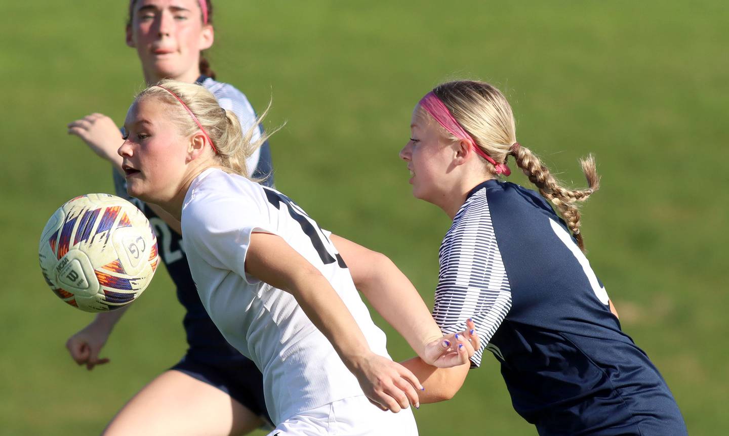 Prairie Ridge’s Maria Falkowska, center, uses her body to move the ball ahead of  Cary-Grove’s Julia Nichols, right,in varsity girls soccer at Cary-Grove High School in Cary on Tuesday, April 29, 2025.