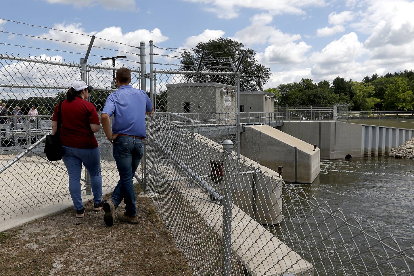 People look at he dam during a completion celebration of the $22 million improvement project of the Stratton Lock and Dam, 2910 State Park Road, in McHenry, on Wednesday, July 13, 2022. The dam, that is operated by Illinois Department of Natural Resources’s Office of Water Resources, to help ensure safe and efficient recreational boating on the Fox River Chain of Lakes. Close to 20,000 watercraft pass through the lock during the boating season.