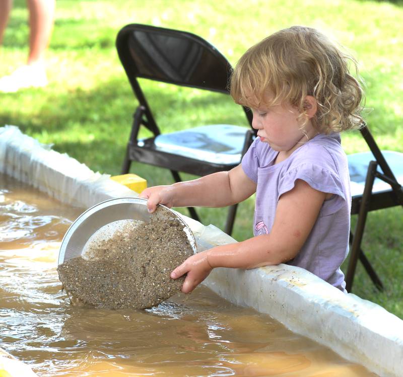 Paisley Countryman, 3, of Forreston, pans for "gold" at one of the activities for kids at German Valley Days on Saturday, July 19, 2025.