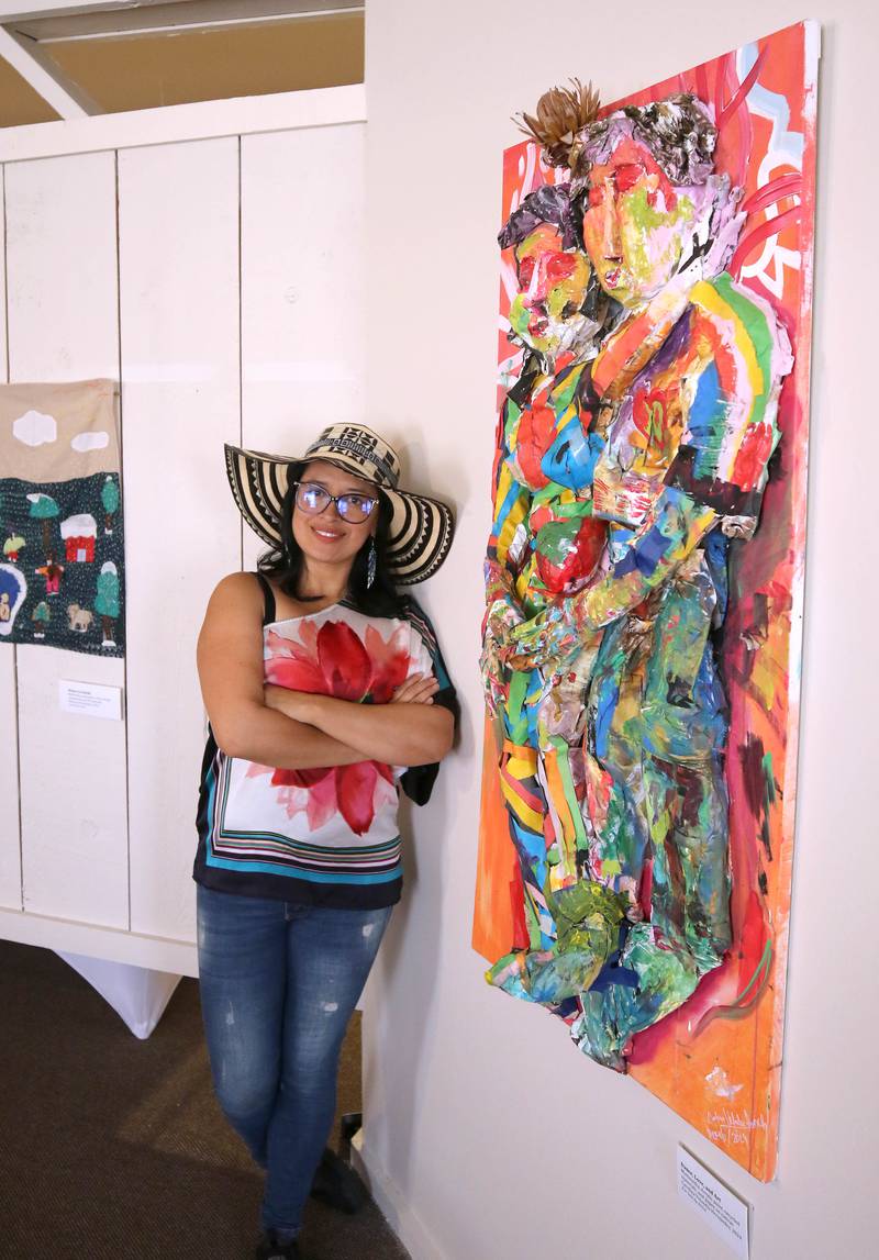 DeKalb resident Carolina Velandia with her work entitled “Dance, Love, and Art” Wednesday, Sept. 18, 2024, that is part of the Arts in Action exhibition at the Ellwood House Museum in DeKalb. The exhibit features work by local Latino artists and runs through the end of the year.