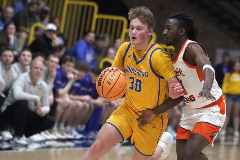 Johnsburg’s Jayce Schmitt, left, drives against against Peoria Manual in boys IHSA Class 2A Supersectional basketball on Monday, Mar. 9, 2026, at Sterling High School in Sterling.