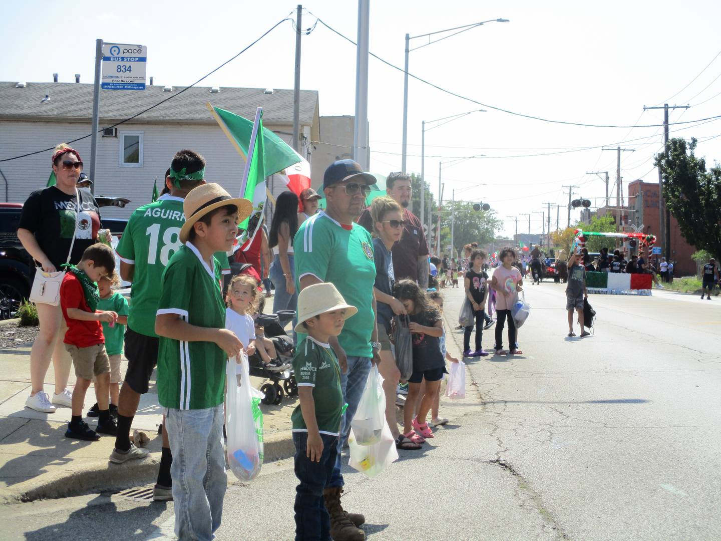 Henry Bernabe (left) waits with his brother Gael Bernabe and Uncle Sabino Torres for the next float of candy throwers during the Mexican Independence Day Parade in Joliet on Saturday, Sept. 16, 2021.