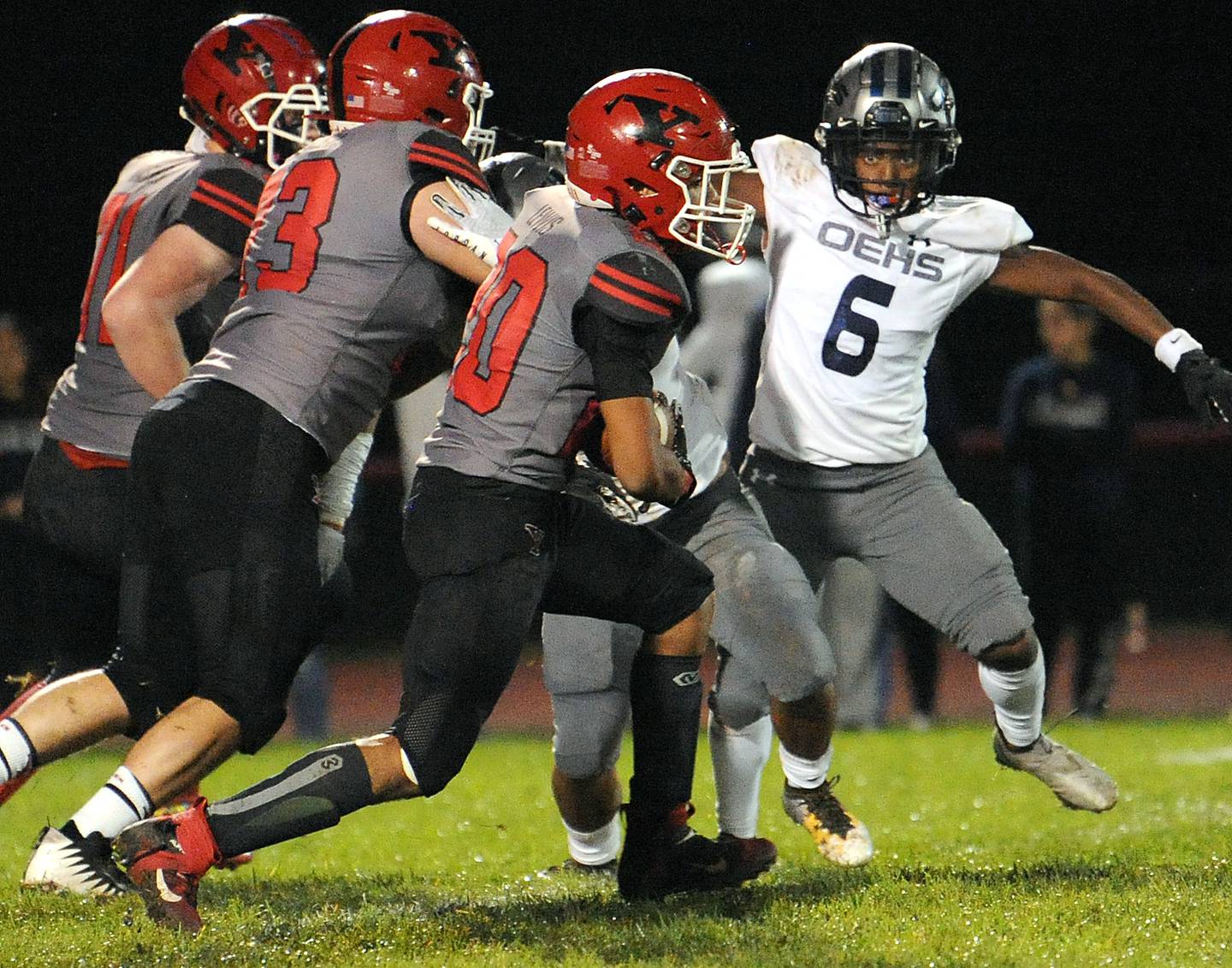 Yorkville running back Deajeion Lewis (20) runs past Oswego East defensive back Jabari Peoples (6) during a varsity football game at Yorkville High School on Friday.