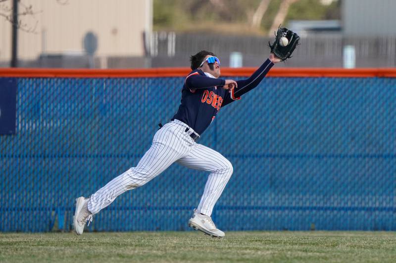 Oswego’s Bryson Norwood (13) makes a catch for an out against Benet during a baseball game at Oswego High School on Tuesday, March 25, 2025.
