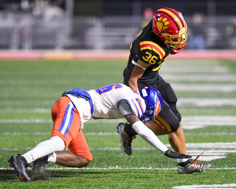 Batavia's Preston Brummel (36) runs the ball while being defended by Hoffman Estates's JMari Jackson (16) during the first round of playoffs on Friday Oct. 31, 2025, held at Batavia High School.