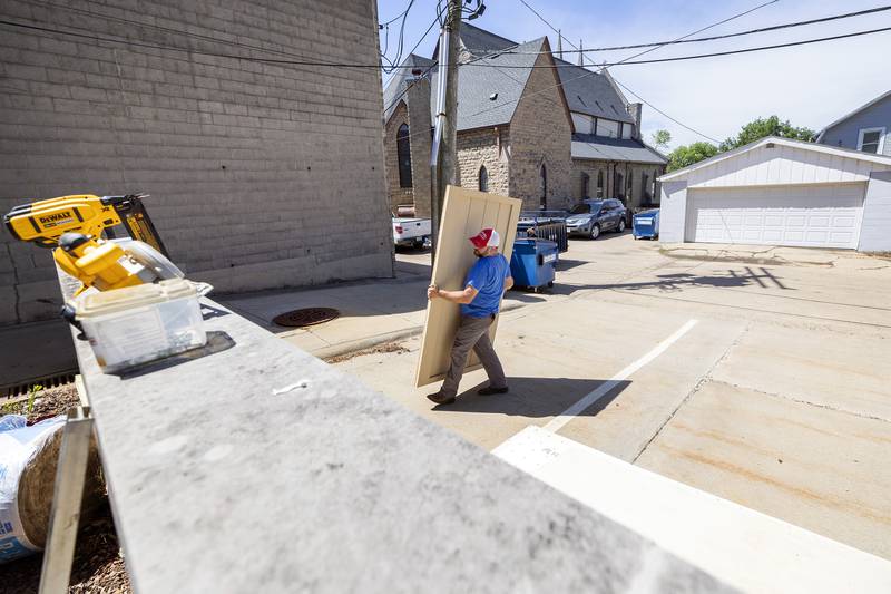 Oregon High School Ag Construction instructor Seth McMillan moves a door into place Friday, May 16, 2025, at Dixon Public Library. The class has built four other centers, but this is the first constructed on-site. One more is planned for the Creston area.