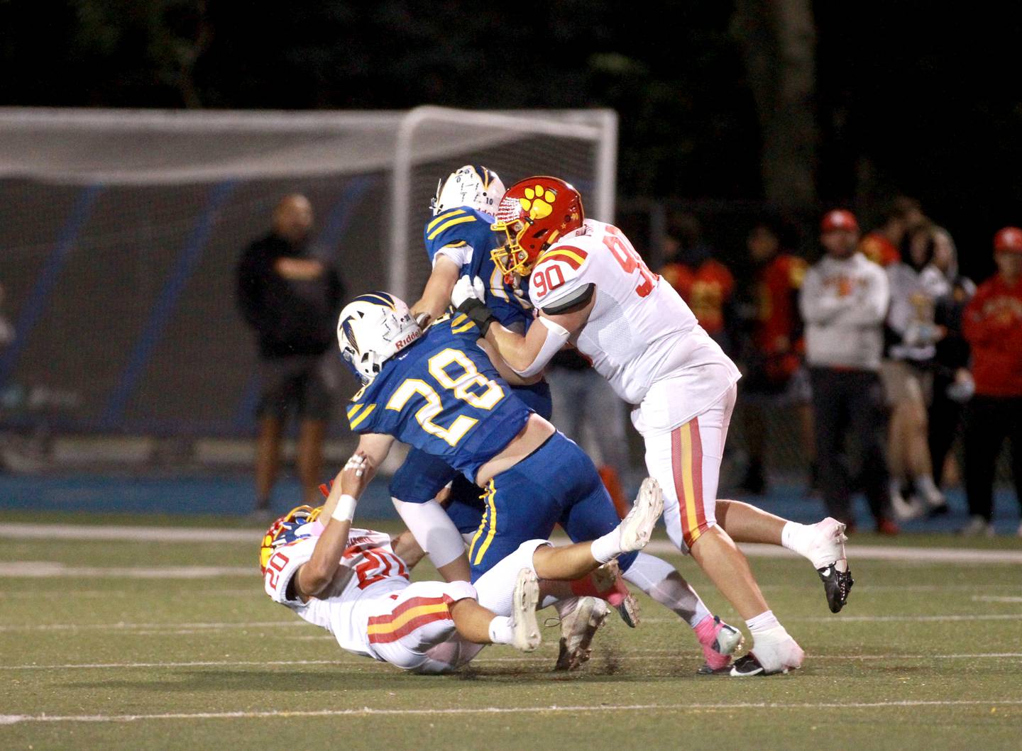 Batavia’s Chase Osborne (far left) and Gavin Pecor (far right) take down Wheaton North quarterback Nick Johnson and Max Serbick in the back field during a game on Friday, Sept. 27, 2024 at Wheaton North.