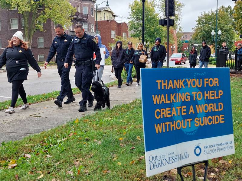 Rookie, the Ottawa Police Department's therapy dog, leads walkers Saturday, Oct. 14, 2023, during the Out of the Darkness Walk at Washington Square in Ottawa.