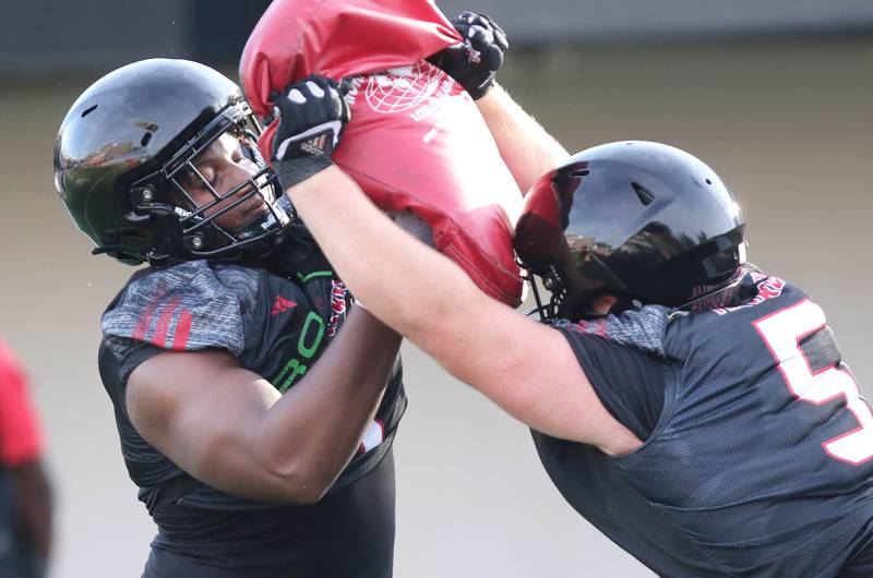 Northern Illinois Huskies defensive tackle James Ester (left) and defensive tackle Cade Haberman work in a drill at the teams first practice of the season Wednesday, Aug. 2, 2023, at Huskie Stadium in DeKalb.