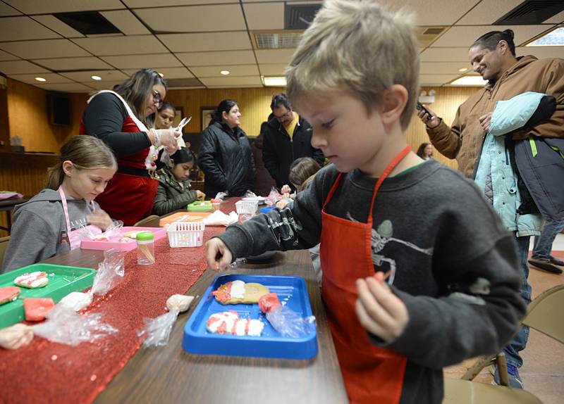 Children including (left) Mabelle Frias of Iowa and Arlo Hosfield of Forest Park decorate cookies during the Berwyn Holiday Pop-Up Market Saturday Dec 10, 2022.