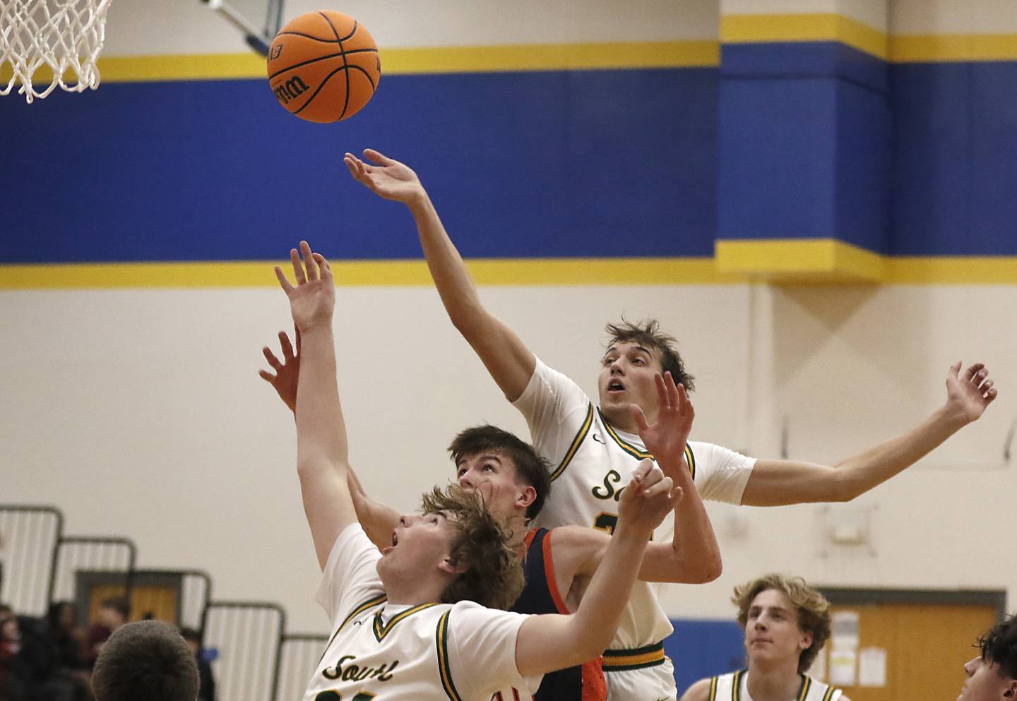 Crystal Lake South's Johnathan Morgan and Anthony Santarelli sandwich Buffalo Grove's Quinn Rowan as they battle for a rebound during a Johnsburg Thanksgiving Tournament boys basketball game on Monday, Nov. 25, 2024, at Johnsburg High School.