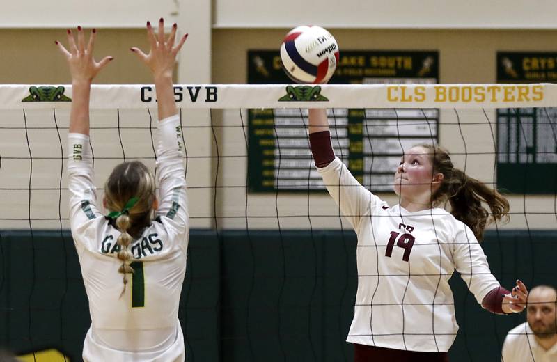 Prairie Ridge's Tegan Vrbancic tips the ball over the block of Crystal Lake South's Olivia Apt during the IHSA Class 3A Crystal Lake South Sectional final volleyball match on Thursday, Nov. 7, 2024, at Crystal Lake South High School.