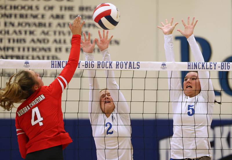 Hinckley-Big Rock’s Anna Herrmann (left) and ILY Hunt try to block the spike during their match against Aurora Christian Tuesday night at the school in Hinckley.