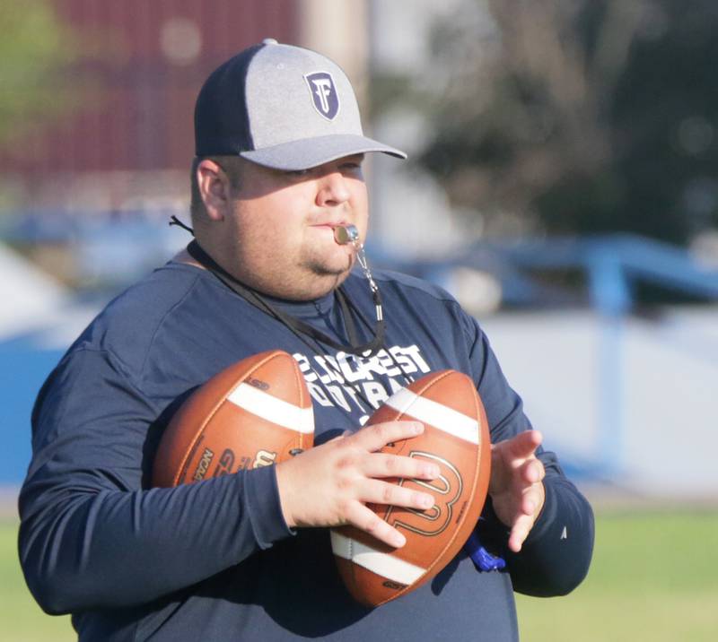 Fieldcrest head coach Nick Meyer blows a whistle during football camp on Monday, July 18, 2022 at New Millenia Park in Minonk.