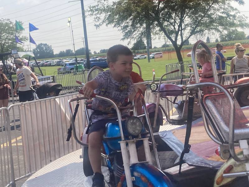 Kids ride the "motorcycle jump" kids ride at the Shorewood Crossroads Festival on Saturday, August 2, 2025.