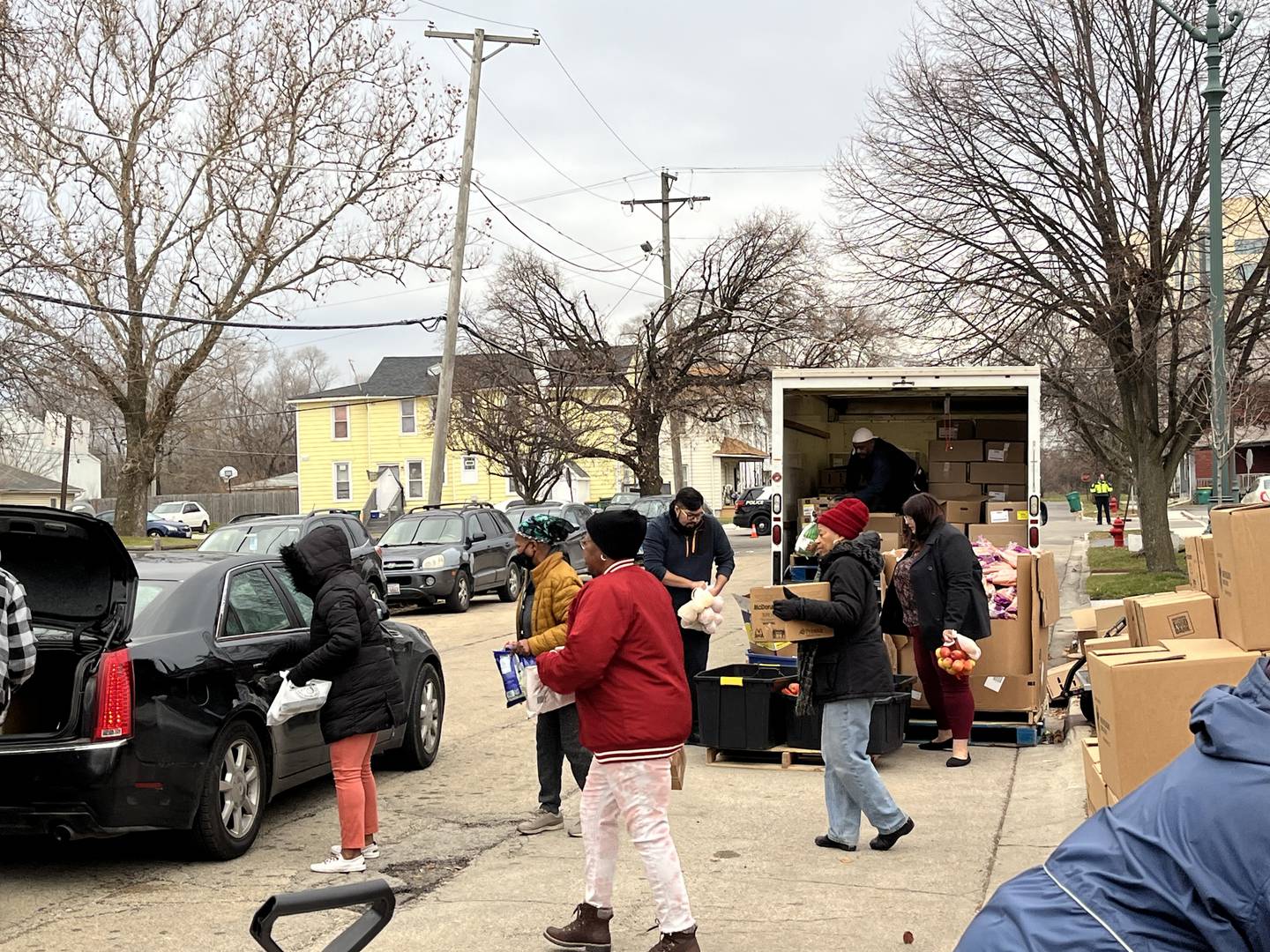 Volunteers bring food to one of numerous vehicles that arrived for a free food pantry event on Thursday, Dec. 21, near Second Baptist Church in Joliet.