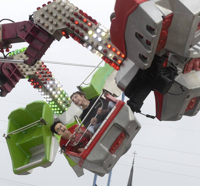Corwin Diaz and Wyatt Wheeler put on brave faces Thursday, July 7, 2022, as they zoom around at high speed on “The Orbitzer” during the Marseilles Fun Days carnival.