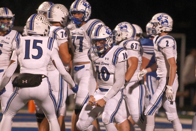 St. Charles North quarterback Ethan Plumb (center) celebrates a touchdown on Friday, Oct. 25, 2024 during a game at Geneva.