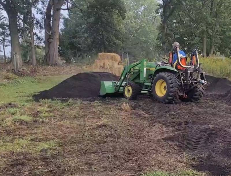 Algonquin Garden Club member's husband Rick Pasturczak. drives a tractor while placing compost donated by East Dundee-based Green Soils for the club's Miyawaki mini-forest project at the Dixie Briggs Fromm Nature Preserve in Dundee Township.