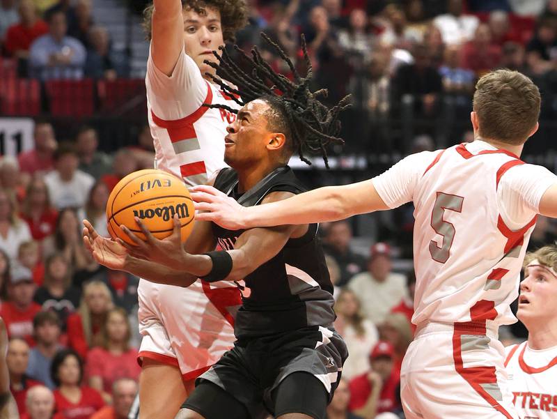 Kaneland's Marshawn Cocroft goes to the basket between two Morton defenders Monday, March 9, 2026, during their IHSA Class 3A supersectional matchup in the Convocation Center at Northern Illinois University in DeKalb.