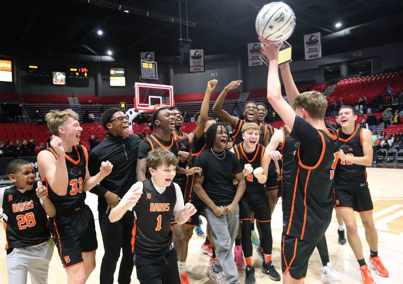 DeKalb players hoist the trophy after their win over Sycamore Friday, Jan. 31, 2025, in the FNBO Challenge in the Convocation Center at Northern Illinois University in DeKalb.