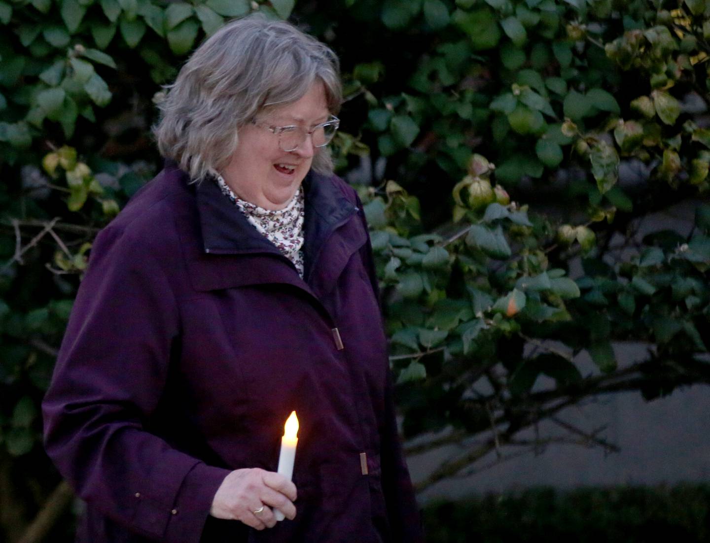 Eileen Fesco of Ottawa, and Zonta Coub member holds a candle while walking in the luminary walk on Tuesday, Oct. 10, 2023 downtown Peru.