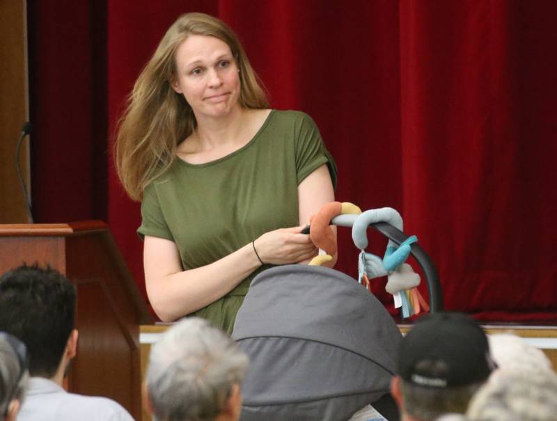 Susan Tutko of Streator, carries her newborn baby after speaking to the Illinois Health Facilities and Services Review Board during a public hearing regarding OSF St. Elizabeth Hospital's plans to reduce services on Tuesday, June 10, at Central Intermediate School in Ottawa.