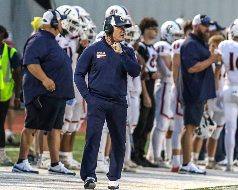 Oswego head football coach Brian Cooney walks the sidelines during a game this season.